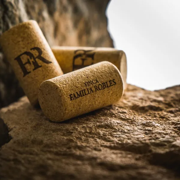 Corchos con las iniciales FR y el nombre Finca Familia Robles, sobre una piedra